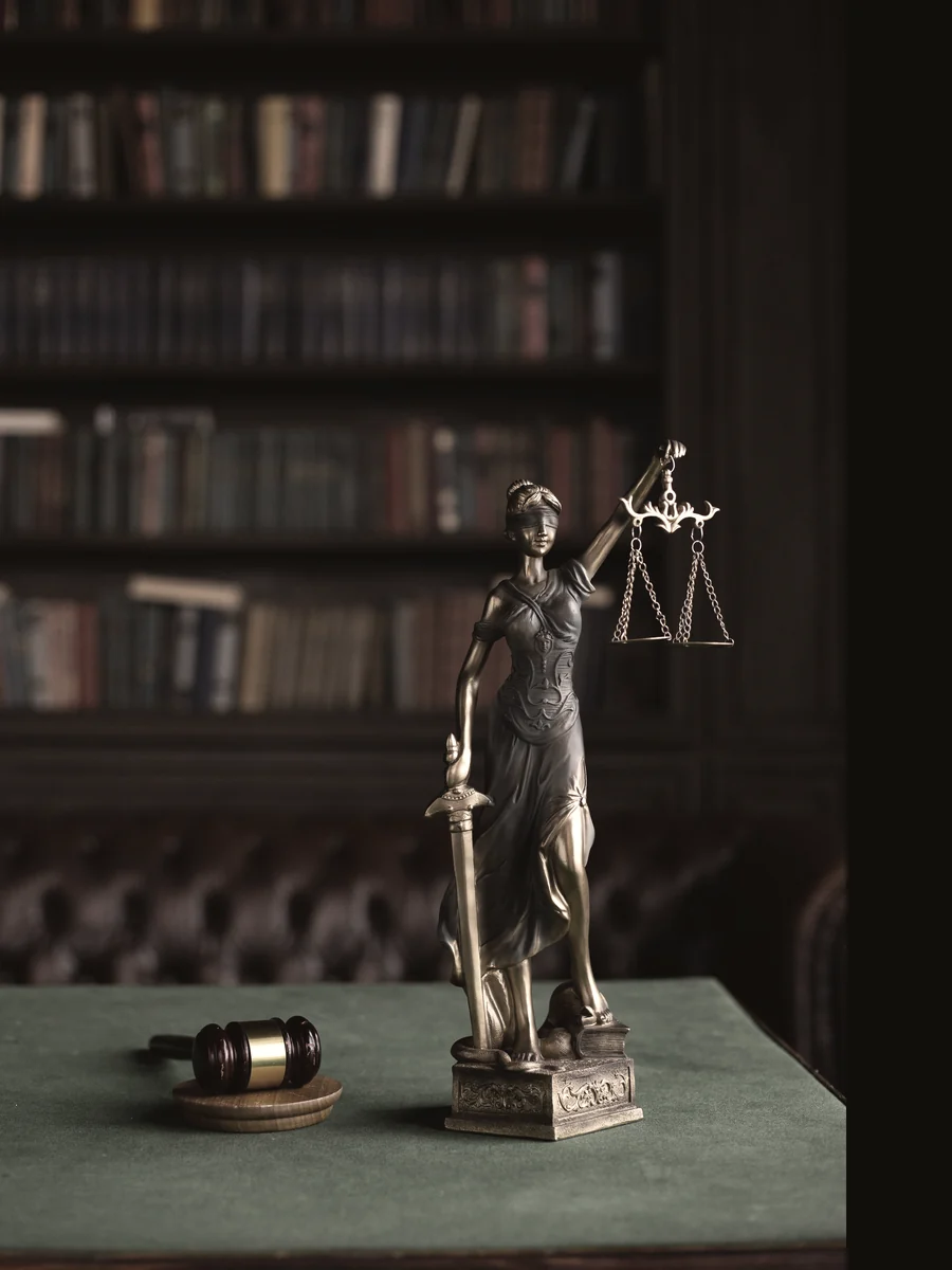 Estatua de la justicia sobre el escritorio de un estudio jurídico